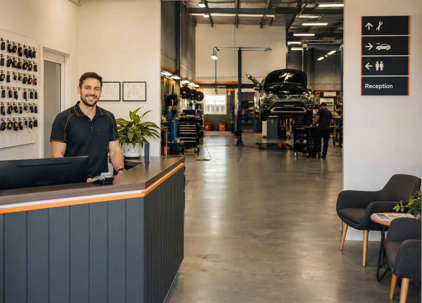 Smiling staff member at a tidy, modern workshop reception desk