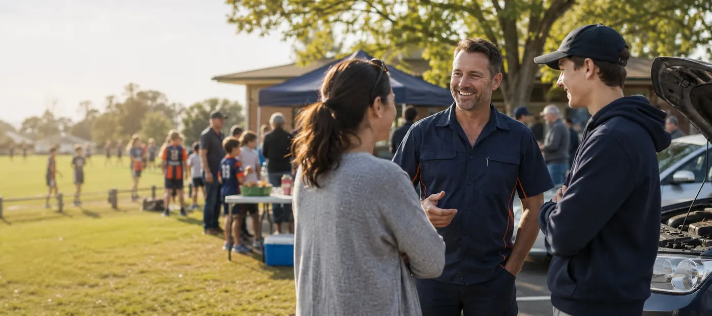 Mechanic chatting with locals at a community sports day